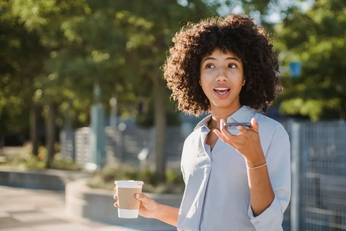 A person speaking into a smartphone outdoors
