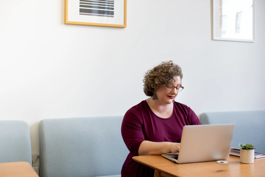 A professional working at a laptop in a bright office